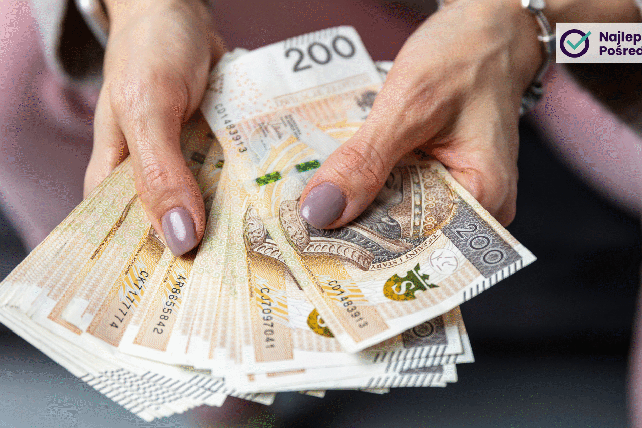 Zadbane kobiece dłonie trzymające plik banknotów o nominale 200 zł