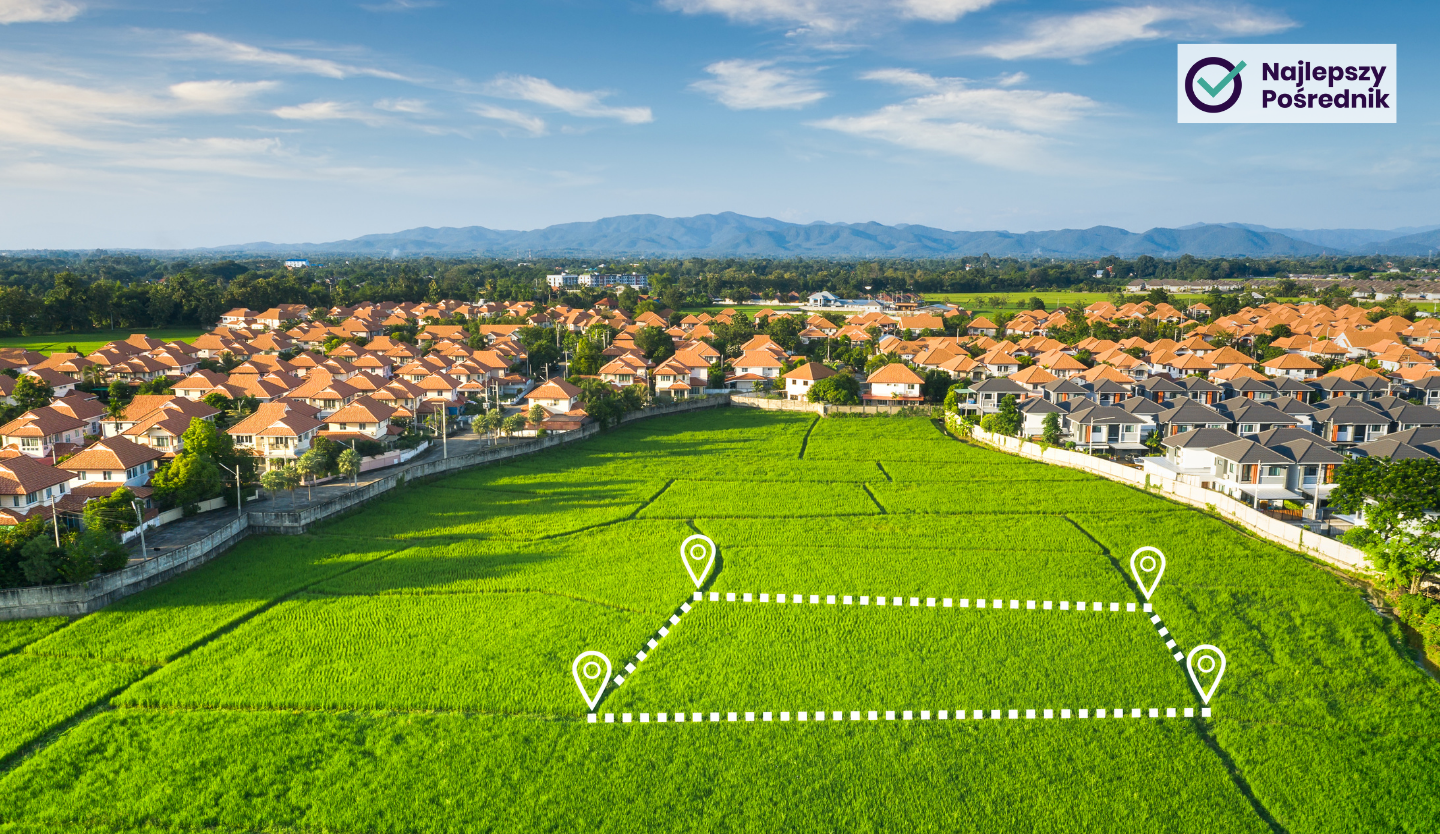Widok z drona na osiedle i pole, na którym zaznaczona jest działka na sprzedaż