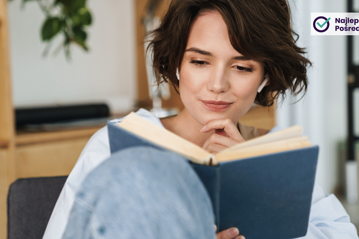 Lekko uśmiechnięta młoda kobieta czyta książkę