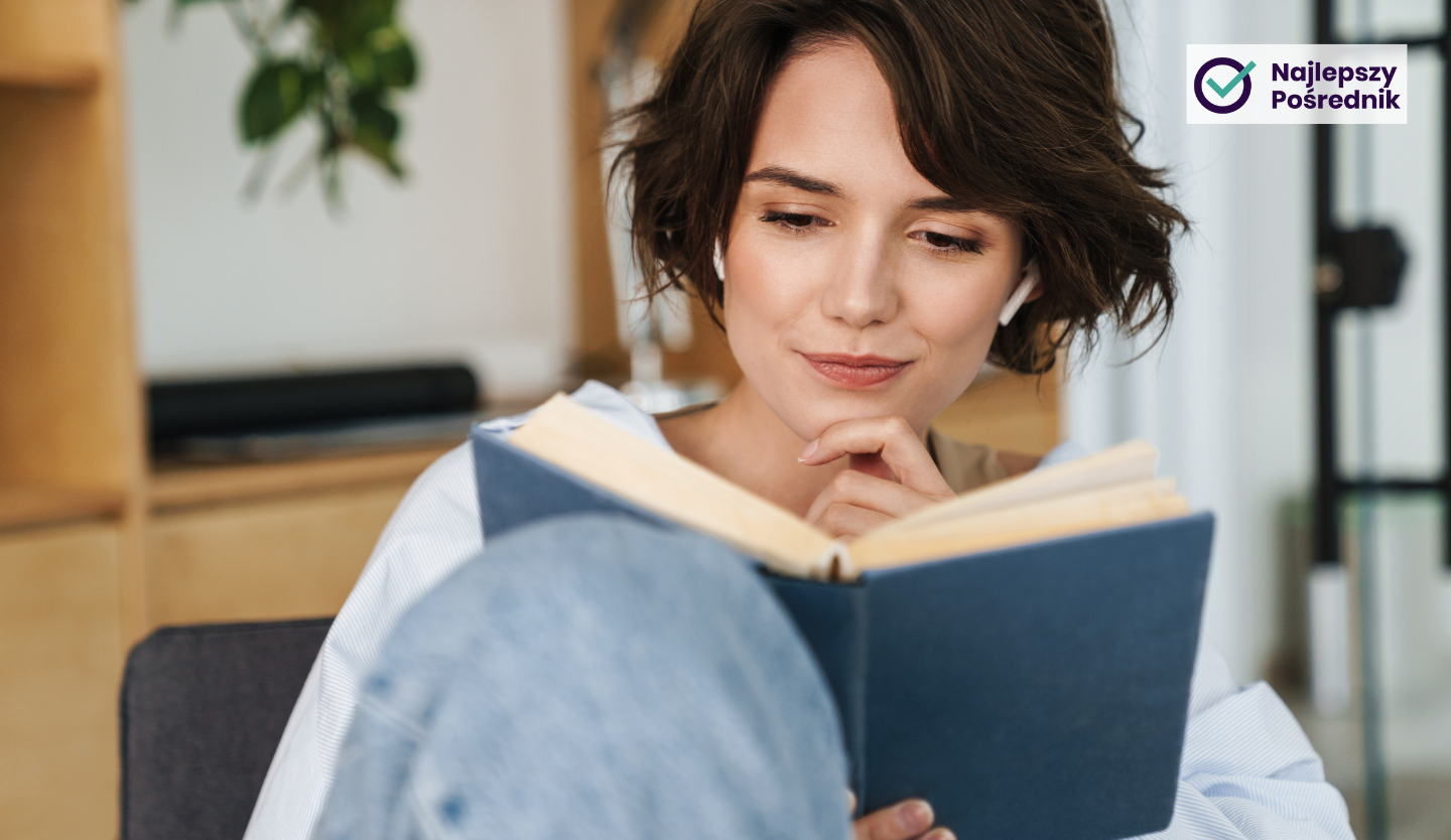 Lekko uśmiechnięta młoda kobieta czyta książkę
